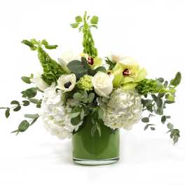 White and green floral arrangement in a glass vase