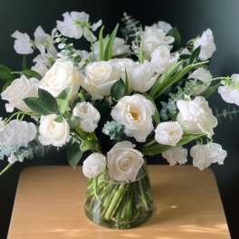 White roses and ranunculus in a clear glass vase