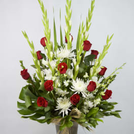 Red roses and white flowers in a tall gray vase