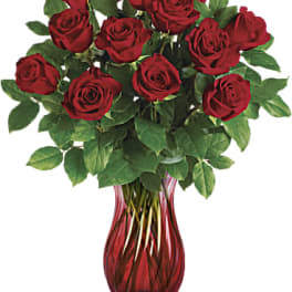 Red roses arranged in a red glass vase