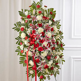 Standing floral spray with red and white flowers and a red ribbon