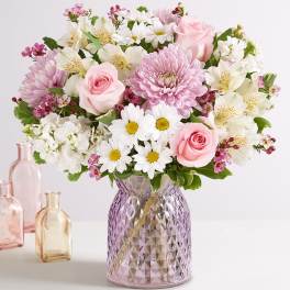 Pink and white mixed bouquet in a purple glass vase