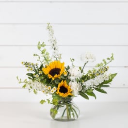 Sunflowers and white flowers in a clear glass vase