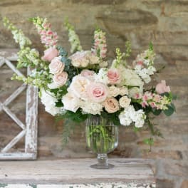 Blush and white rose arrangement in a clear glass vase
