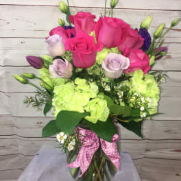 Pink and lavender roses with lime hydrangeas in a glass vase