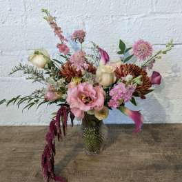 Mixed pink and cream floral arrangement in a glass vase
