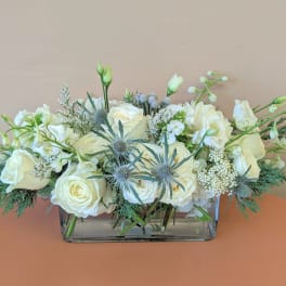 White rose arrangement in a rectangular glass vase