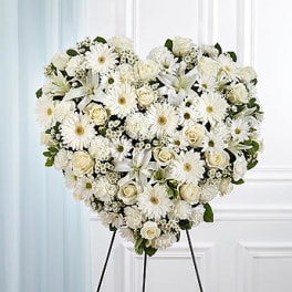 Heart-shaped white floral standing spray on an easel