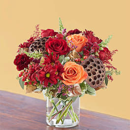 Bouquet of red and orange roses in a clear glass vase