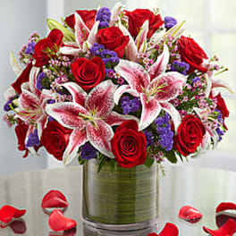 Bouquet of red roses and pink lilies in a glass vase