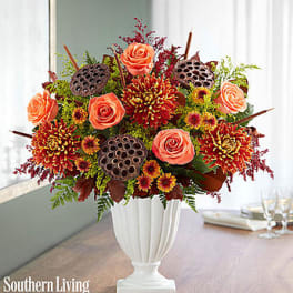 Orange roses and mums arranged in a white vase