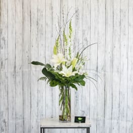Tall white lily arrangement in a clear glass vase
