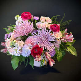 Bouquet of pink and lavender flowers in a white vase