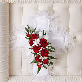 Red rose bouquet with white baby's breath and ribbon on a lace pillow