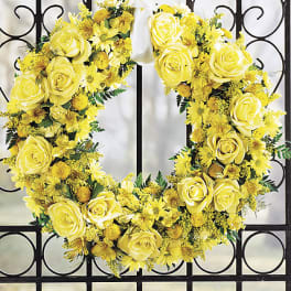 Yellow rose and daisy wreath with a white ribbon bow