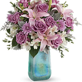 Pink roses and lilies in a blue glass vase