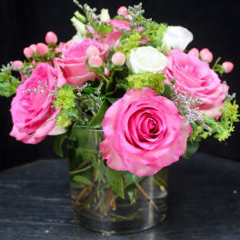 Pink and white roses arranged in a clear glass vase