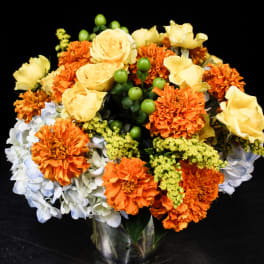 Orange and yellow flower arrangement in a glass vase