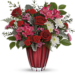 Red and pink mixed bouquet in a red glass vase