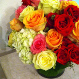 Bouquet of multicolored roses with pale hydrangea in a vase