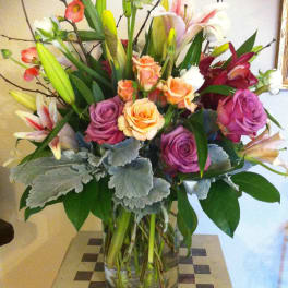 Mixed bouquet of roses and lilies in a clear glass vase