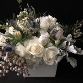 White rose arrangement in a white rectangular vase with lavender accents