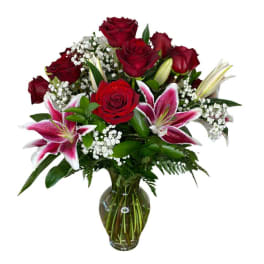 Red roses and pink lilies arranged in a glass vase