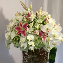 White orchids and pink lilies arranged in a glass vase