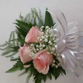 Pink roses with baby's breath and a white ribbon bow