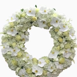 Large white and ivory floral wreath featuring orchids, roses, and hydrangeas