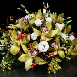 Yellow orchids and white blooms arranged with orange berries