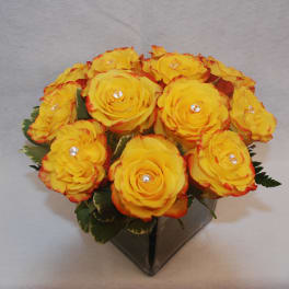 Yellow roses in a square glass vase
