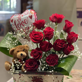 Red roses in a gift box with a teddy bear and heart balloon