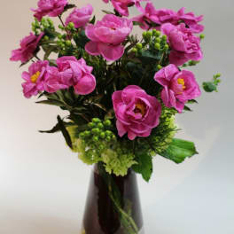 Pink flowers arranged in a dark glass vase