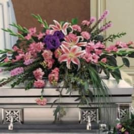 Large pink and purple floral casket spray with lilies and carnations