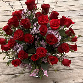 Bouquet of red roses with pink filler flowers in a glass vase