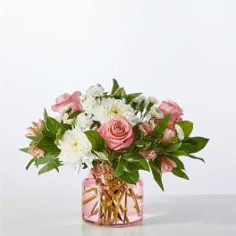 Pink roses and white daisies in a pink glass vase