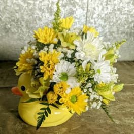 Yellow and white daisy bouquet in a yellow duck container