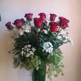 Tall vase arrangement of red roses and white filler flowers