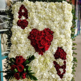 Large floral display of white hydrangeas with red rose hearts