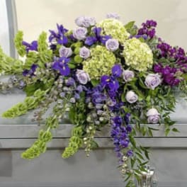Large purple and green floral casket spray with lavender roses