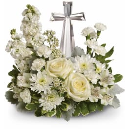 White floral arrangement with a silver cross centerpiece