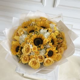 Yellow roses and sunflowers in a wrapped bouquet