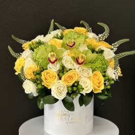 Round bouquet of yellow and white roses in a white hat box