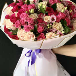 Large bouquet of pink and cream roses wrapped in white paper