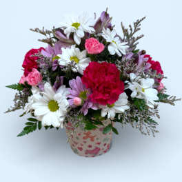 Bouquet of daisies, carnations, and purple flowers in a patterned pot