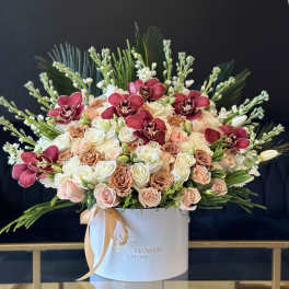 Large rose arrangement with burgundy orchids in a white hat box