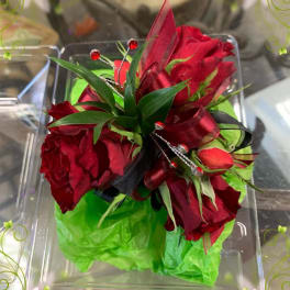 Red rose bouquet with green wrap and ribbon in a clear box