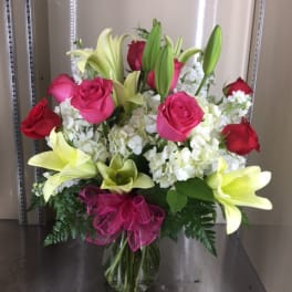 Bouquet of pink roses and white lilies in a glass vase