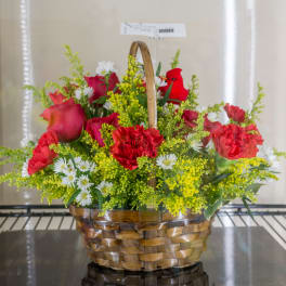 Basket arrangement of red carnations and roses with white daisies